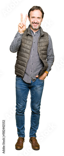 Middle age handsome man wearing winter vest showing and pointing up with fingers number two while smiling confident and happy. photo