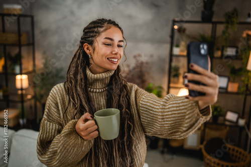 beautiful smiling young woman take a self portrait with mug at home photo