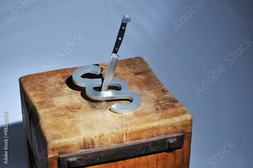 Hamburg, Germany - March 4, 2023: Close-up of a paragraph sign and a knife - Symbol for injustice, wrong judgments, and judicial injustice by the police and judiciary
