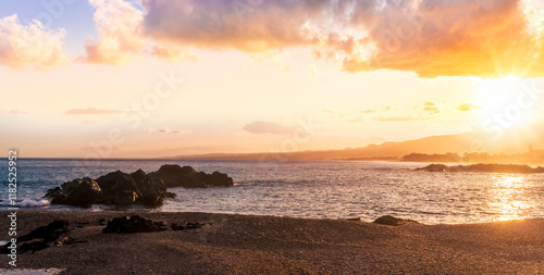 beautiful coast beach with sea gulf water during sunset or sunrise with golden sand, nice black rocks and stones, colorful vawes and clouds in thr sky photo