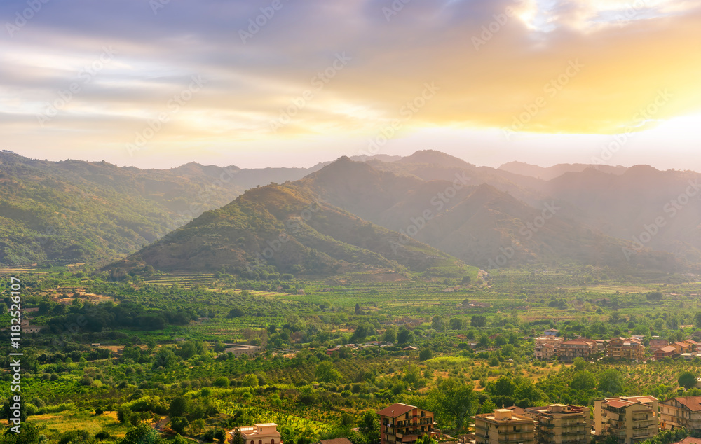 Obraz premium scenic panorama of italian town during sunset with amazing view from above to nice city with picturesque mountain valley landscape and cloudy sky on backdrop