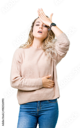 Beautiful young blonde woman wearing sweatershirt over isolated background surprised with hand on head for mistake, remember error. Forgot, bad memory concept. photo