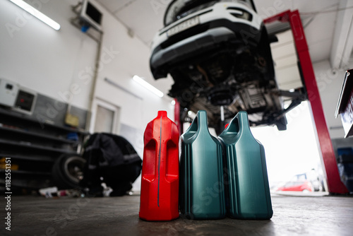 Car repair shop with oil containers and lifted vehicle photo