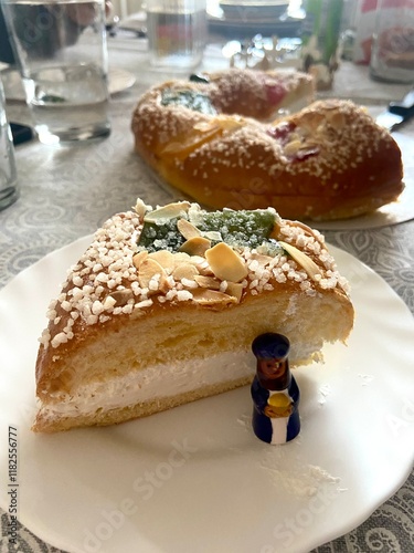 Close-Up of Roscon de Reyes with a Slice Revealing the Hidden Figurine Prize, Captured in a Side Perspective