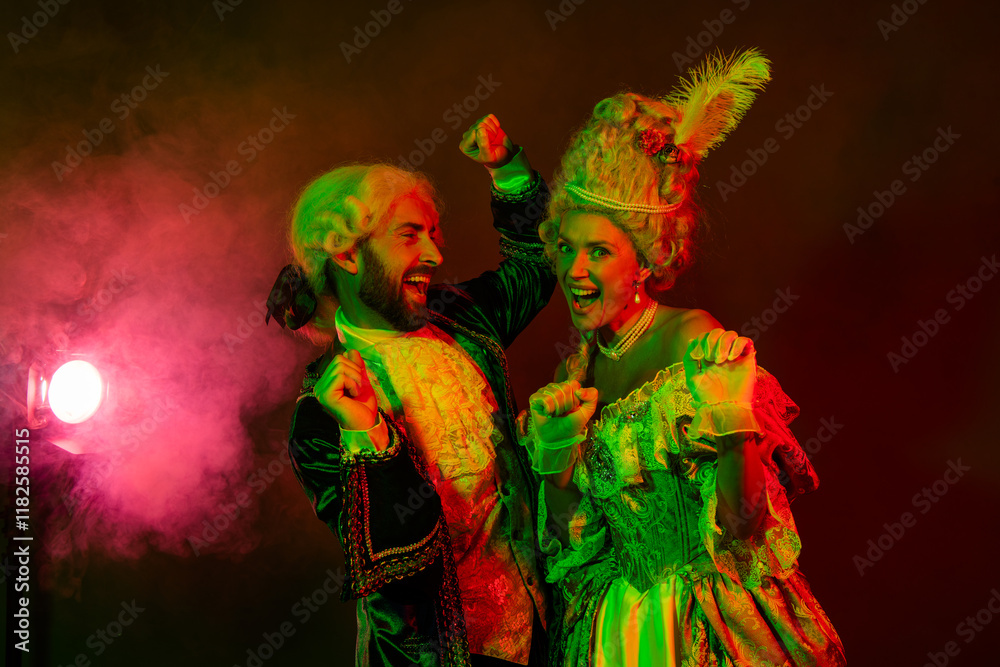 Fototapeta premium Elegant Couple Dressed in Historical Noble Costumes Dancing Joyfully at a Vibrant Club Scene with Colorful Lighting