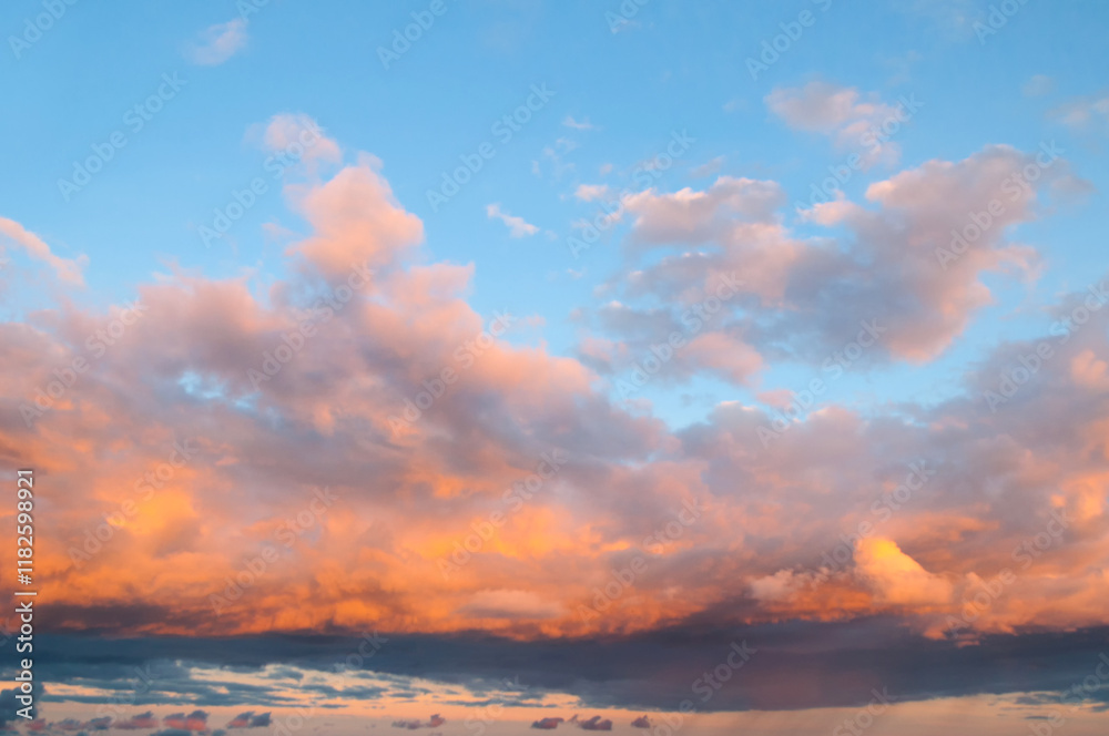 Fototapeta premium Sunset sky landscape, picturesque vast panoramic view of pink and orange sky clouds lit by evening sunlight. Sweeping sky landscape panoramic scene