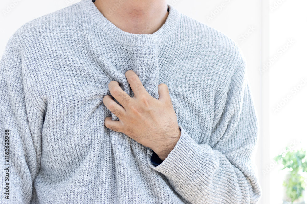 胸を押さえて苦しむセーターを着た男性(30代、日本人、顔無し)