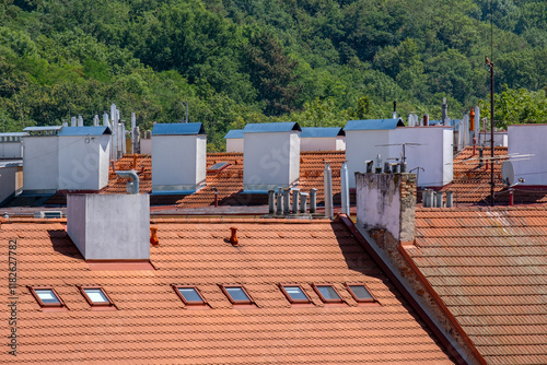 roofs and chimneys around Prague 5 and green trees in the background