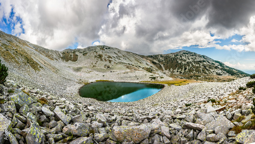 Gorno Todorino lake among rocks and Mt. Todorka slope in summer cloudy day. A typical mountain landscape in Balkans. Pirin mountains near Bansko, Bulgaria. photo