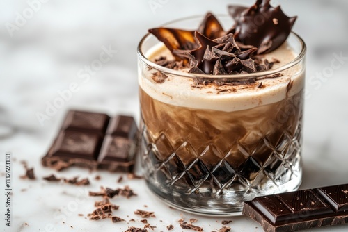 This delightful treat features a thick liqueur topped with creamy foam and an array of chocolate decorations. Served in a stylish glass, it tempts with its luxurious texture and flavor