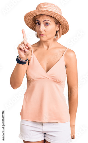 Young blonde woman wearing summer hat pointing with finger up and angry expression, showing no gesture