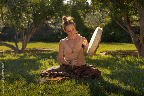 young woman playing shamanic drum