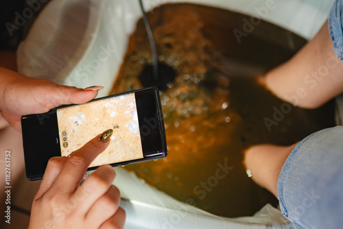 Woman taking photo of ionic detox result. 