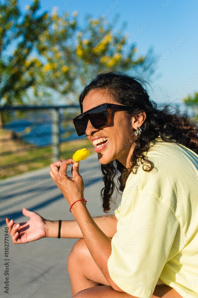 Woman sitting in a park eating ice cream Woman sitting in a park eating ice cream