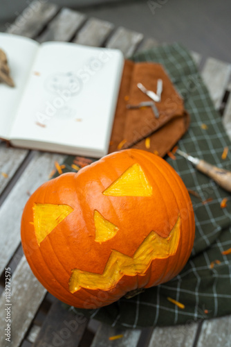 Partially carved jack-o'-lantern pumpkin on a table photo