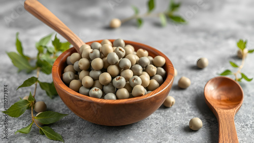 Cicerchia or indian pea in a wooden bowl and spoon on grey table background, gluten free food. Legumes known as Lathyrus Sativus, Chickling Vetch, Blue Sweet Pea made in Puglia, close up, copy space photo