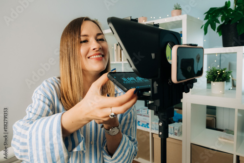 Smiling woman setting up teleprompter for video recording