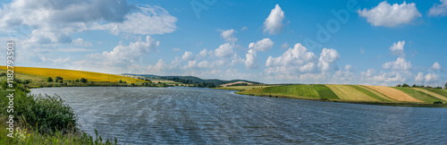 A panoramic view across the reservoir to hilly fields with rapeseed, sunflowe...