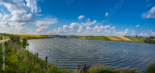 A panoramic view across the reservoir to hilly fields with rapeseed, sunflowe...