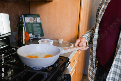 A man makes fried eggs photo