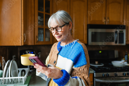 A woman uses a mobile phone at home photo