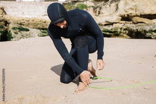 A young surfer putting the leash on photo