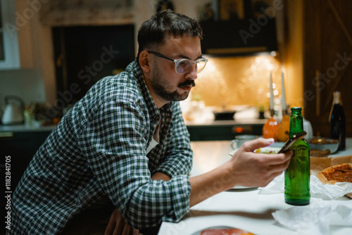 A man uses a mobile phone during dinner at home photo