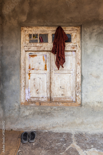 Khan Sahib Tehsil, Jammu and Kashmir, India. Peeling white paint on a wooden shuttered window. photo