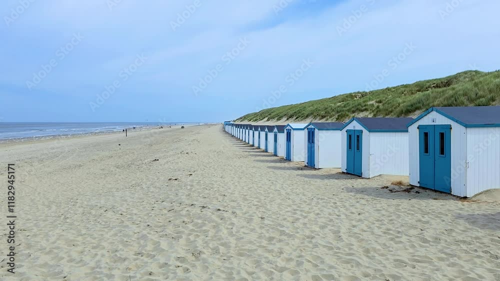 Colorful beach huts sit neatly in a row along the sandy shore of a peaceful Texel Netherlands beach. Gentle waves lap at the shore under a clear blue sky. The scene evokes relaxation and joy. Colorful beach huts sit neatly in a row along the sandy shore of a peaceful Texel Netherlands beach. Gentle waves lap at the shore under a clear blue sky. The scene evokes relaxation and joy.