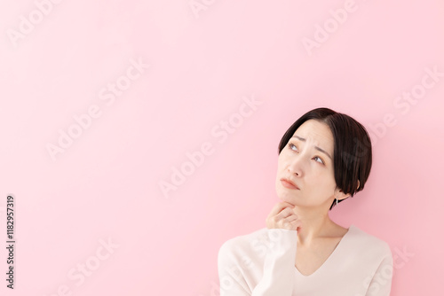 悩む・考える・困る女性・ピンクバック
