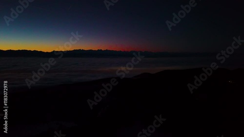 Very early phase of the last sunrise of the year 2024. View on the central and east part of Swiss Alps. Central Switzerland hiding under beautiful cover of clouds. 31.12.2024