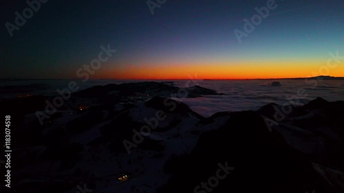 Very early phase of the last sunrise of the year 2024. View on the east and central part of Swiss Alps. Central Switzerland hiding under beautiful cover of clouds. 31.12.2024