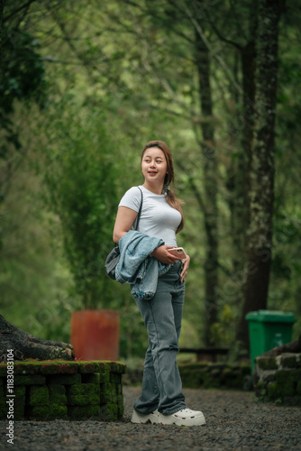 Happy Woman in Casual Outfit Enjoying a Peaceful Forest Setting Outdoors