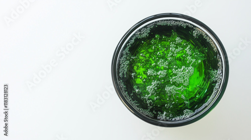 Close-up of a glass of water with a faint greenish tint, symbolizing arsenic contamination, on a plain white background with copy space. Environmental pollution and toxic substance danger concept.