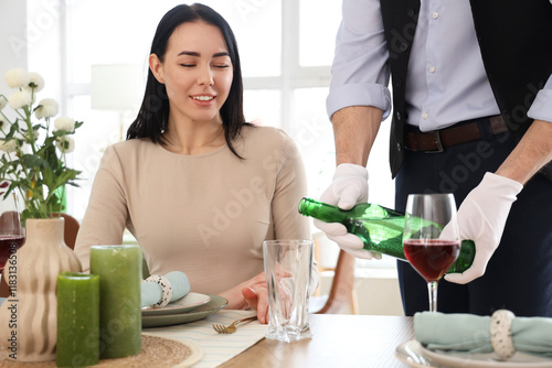 Male waiter pouring water f...