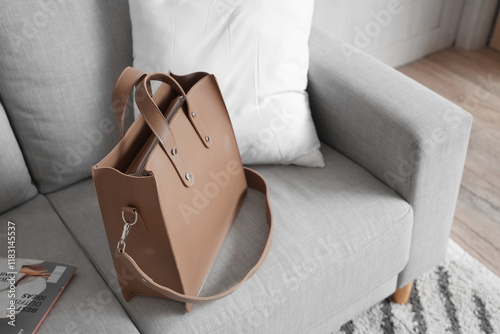 Stylish bag on grey sofa in...