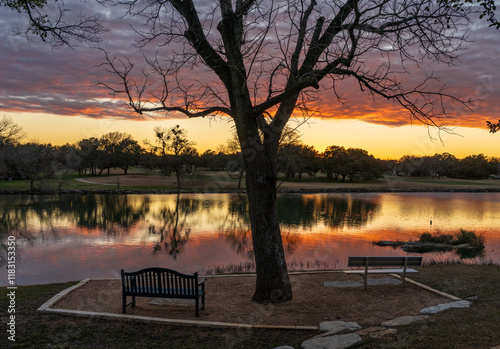 Fotografie Dramatic sunset lighting a layer of clouds and reflected in the still water of L