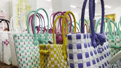 Colorful Woven Plastic Handbags Displayed in a Store Brightly Colored Plastic Bags on a Shelf photo