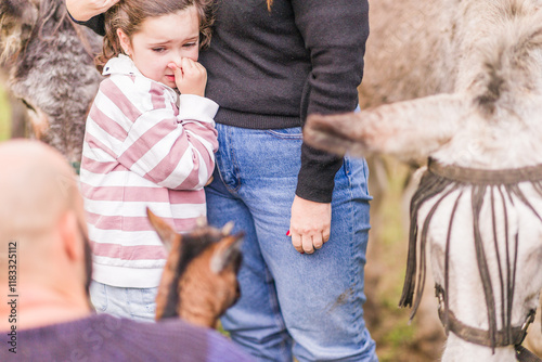 scared girl experiencing fear of animals at sanctuary for farm environment photo