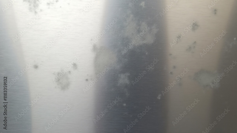 Fototapeta premium Polished metal surface with faint, opaque marks, creating a contrast between shiny and matte sections, giving it a weathered, yet elegant look.