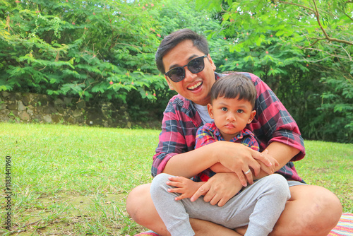 family, leisure and people concept - happy asian father and one little sons having picnic at summer park