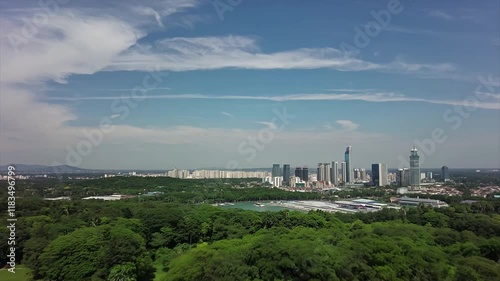 Stunning Aerial View of Urban Skyline Surrounded by Lush Greenery | Modern High-Rise Buildings, Blue Sky, and Harmonious Nature-Cityscape Blend