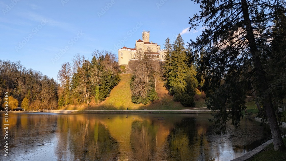 Beautiful winter scenery of Trakošćan Castle on the hill by the lake in the forest at Croatia, county hrvatsko zagorje, nature background