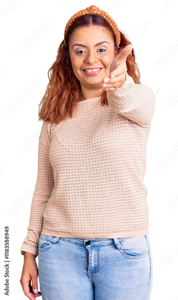 Fototapeta premium Young latin woman wearing casual clothes and diadem smiling friendly offering handshake as greeting and welcoming. successful business.