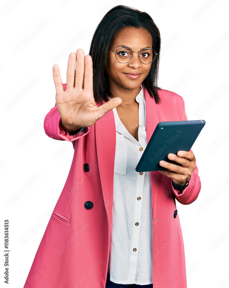 Beautiful hispanic woman using touchpad device with open hand doing stop sign with serious and confident expression, defense gesture Beautiful hispanic woman using touchpad device with open hand doing stop sign with serious and confident expression, defense gesture