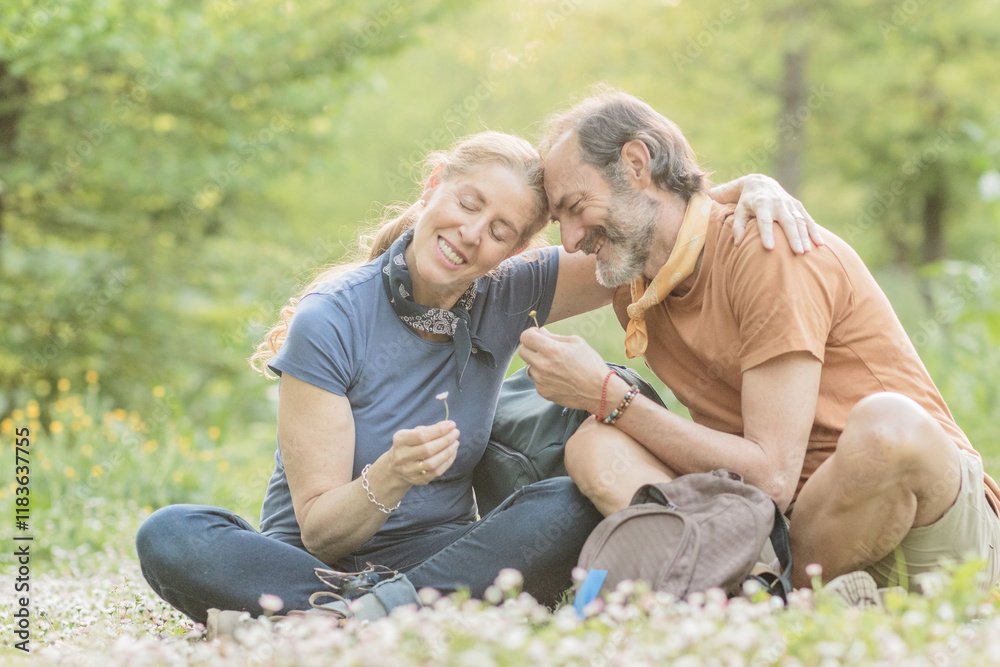 He loves me... he loves me not Happy senior couple enjoying hiking and discovering nature He loves me... he loves me not Happy senior couple enjoying hiking and discovering nature