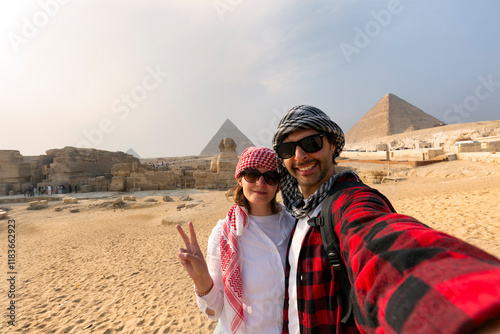 Young Couple taking selfie photo in front of the Great Pyramids of Giza, Egypt