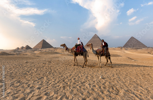 Great Pyramids of Giza - couple riding camels on the desert