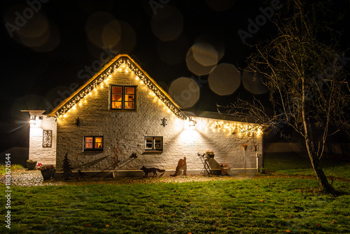 Beautifully illuminated cosy traditional thatched roof house in Northern Germany at night