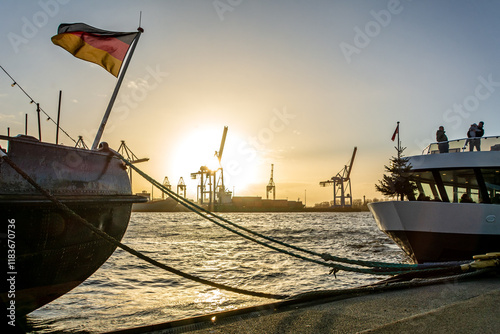 Historic ship German flag and ferry at the pier of the Elbe River in Hamburg